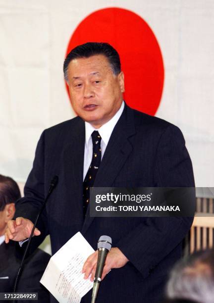 Japanese Prime Minister Yoshiro Mori, who is also president of the ruling Liberal Democratic Party , speaks before the Japanese national flag during...