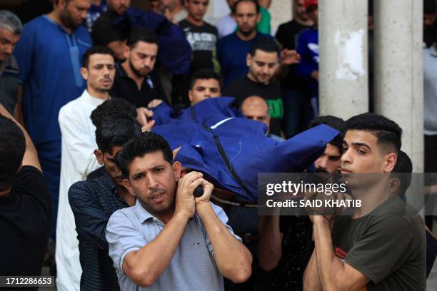 Mourners carry the body of a person killed in Israeli strikes on the Palestinian city of Rafah in the southern Gaza Strip, during the funeral of the...