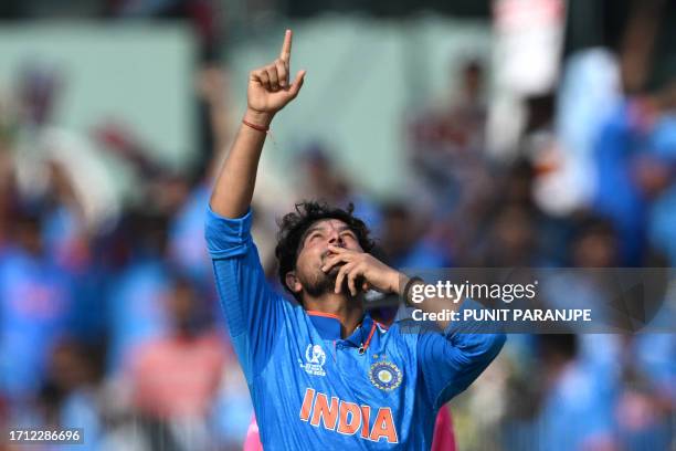 India's Kuldeep Yadav celebrates after taking the wicket of Australia's David Warner during the 2023 ICC Men's Cricket World Cup one-day...