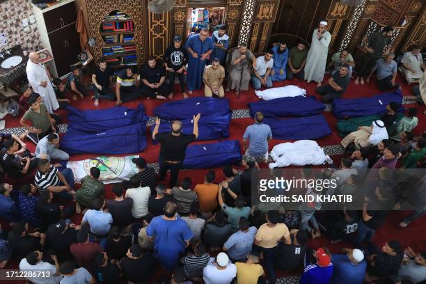 People gather at a mosque to pray over the bodies of the Abu Quta family and their neighbours, killed in Israeli strikes on the Palestinian city of...