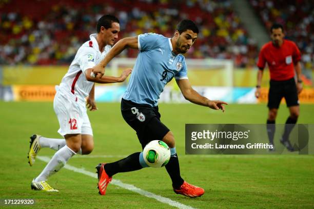 Luis Suarez of Uruguay competes against Edson Lemaire of Tahiti during the FIFA Confederations Cup Brazil 2013 Group B match between Uruguay and...