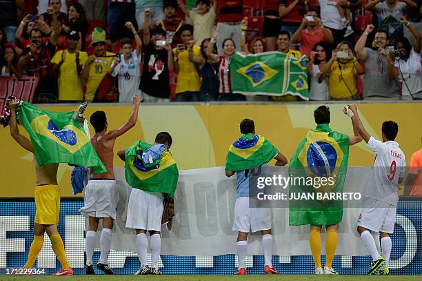 Players of Tahiti acknowlegde the crowd showing a banner reading "Thank You Brazil" and carrying Brazilian national flags, after being defeated by...