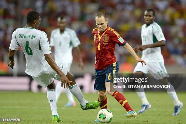 Spain's midfielder Andres Iniesta is marked by Nigeria's defender Azubuike Egwuekwe during the FIFA Confederations Cup Brazil 2013 Group B football...