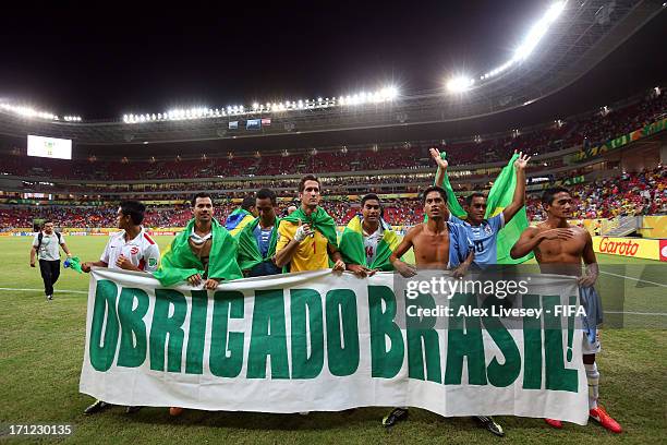 Tahiti holds up a sign reading "Obrigado Brasil" after the FIFA Confederations Cup Brazil 2013 Group B match between Uruguay and Tahiti at Arena...