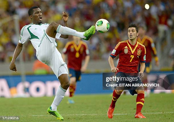 Nigeria's defender Azubuike Egwuekwe kicks the ball as Spain's forward David Villa looks on during their FIFA Confederations Cup Brazil 2013 Group B...