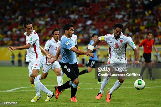 Luis Suarez of Uruguay battles for the ball with Nicolas Vallar and Edson Lemaire of Tahiti during the FIFA Confederations Cup Brazil 2013 Group B...