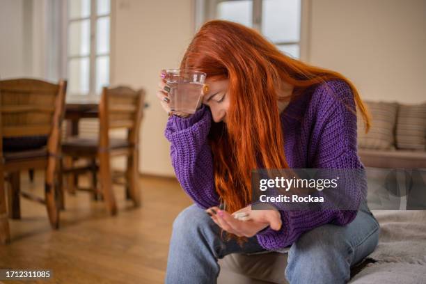 jeune femme dans la douleur - prendre des cachets photos et images de collection