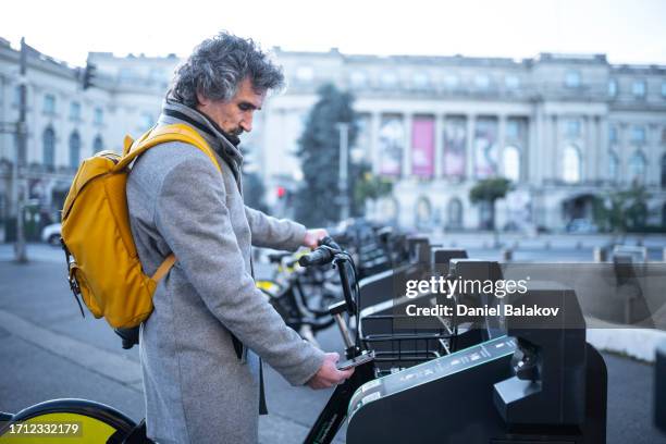 mobilité urbaine durable. homme louant un vélo de ville. - bucarest photos et images de collection