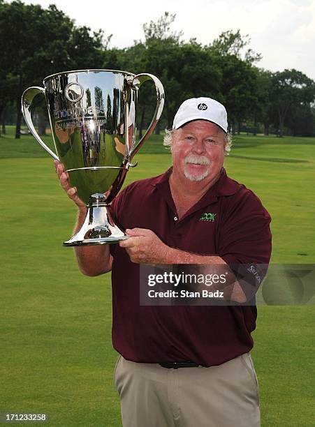 Craig Stadler poses with the winner's trophy on the 18th green after the final round of the Encompass Championship at North Shore Country Club on...