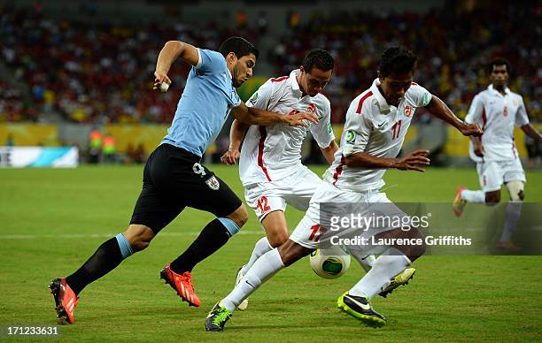 Luis Suarez of Uruguay battles for the ball with Edson Lemaire and Jonathan Tehau of Tahiti during the FIFA Confederations Cup Brazil 2013 Group B...