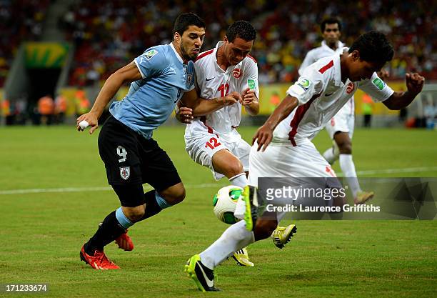 Luis Suarez of Uruguay battles for the ball with Edson Lemaire of Tahiti during the FIFA Confederations Cup Brazil 2013 Group B match between Uruguay...