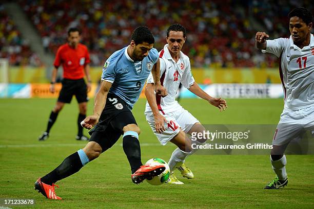 Luis Suarez of Uruguay tries to pass in between Edson Lemaire and Jonathan Tehau of Tahiti during the FIFA Confederations Cup Brazil 2013 Group B...