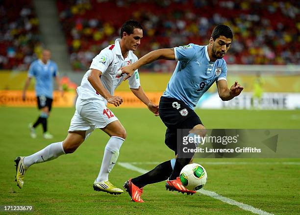 Luis Suarez of Uruguay is chased by Edson Lemaire of Tahiti during the FIFA Confederations Cup Brazil 2013 Group B match between Uruguay and Tahiti...