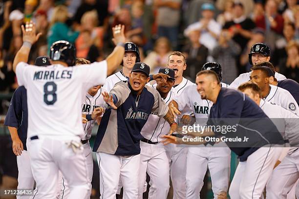 Kendrys Morales of the Seattle Mariners is congratulated by teammates after hitting a walk-off three-run home run in the tenth inning against the...