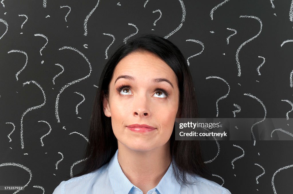 Woman with question marks on a blackboard