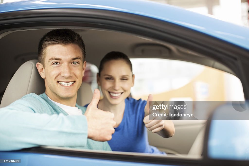 Young Couple Gesturing Thumbs Up