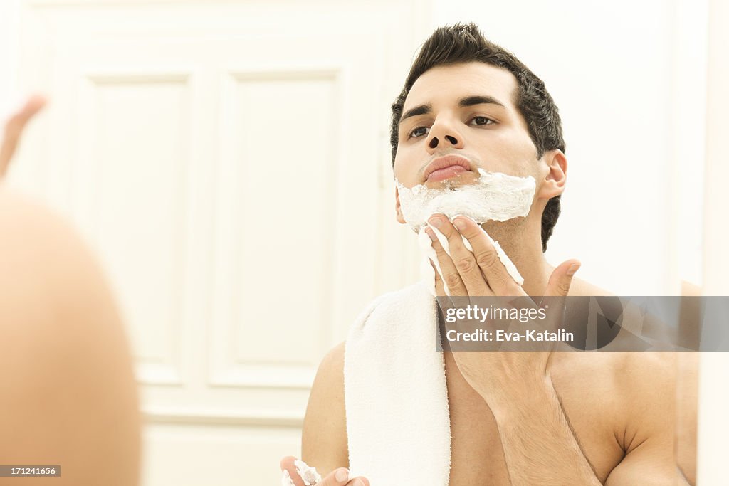 Young man applying shaving cream