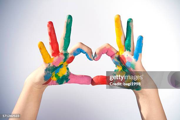 hands covered in paint making a heart sign - painted hands stock pictures, royalty-free photos & images