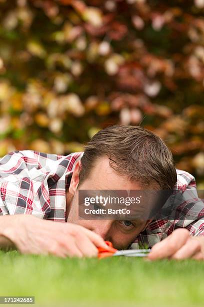 man with shear on grass - cutting grass with scissors stock pictures, royalty-free photos & images