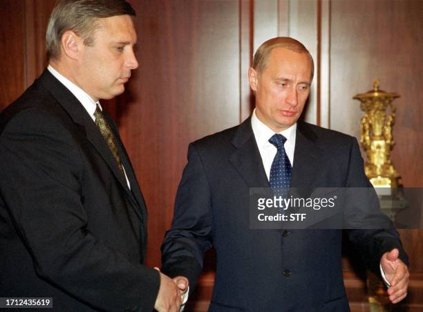 Russian President Vladimir Putin shakes hands with Prime Minister Mikhail Kasyanov inviting him to start their talks in Moscow's Kremlin, 21 August...