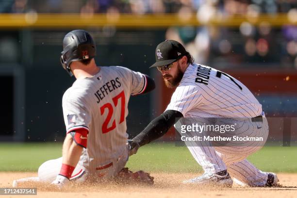 Brendan Rodgers of the Colorado Rockies tags out Ryan Jeffers of the Minnesota Twins trying to stretch a single into a double in the eighth inning at...