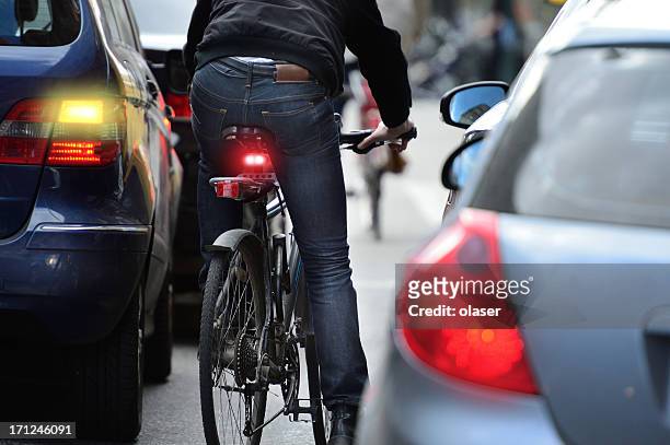 man on bicycle in traffic - traffic stock pictures, royalty-free photos & images