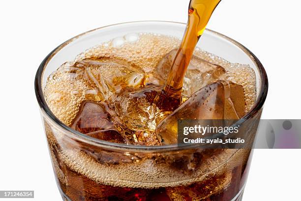 soda être versé dans le verre avec de la glace - coca cola photos et images de collection