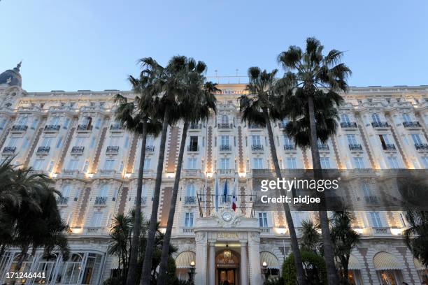 illuminated facade of the intercontinental carlton cannes hotel at dusk - cannes building stock pictures, royalty-free photos & images