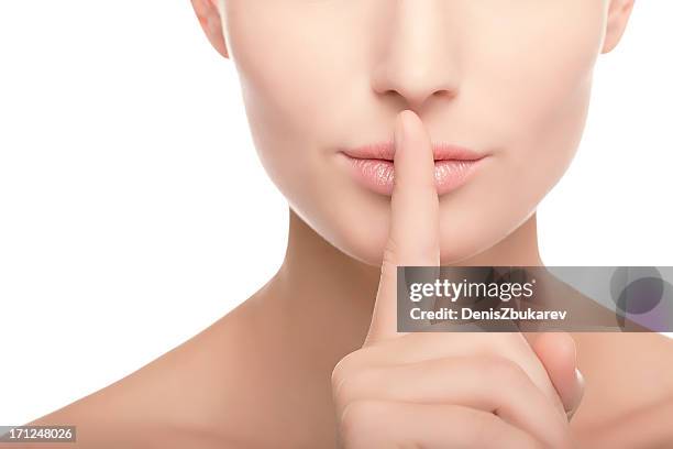 young woman with finger on her lips - woman with finger on lips stock pictures, royalty-free photos & images