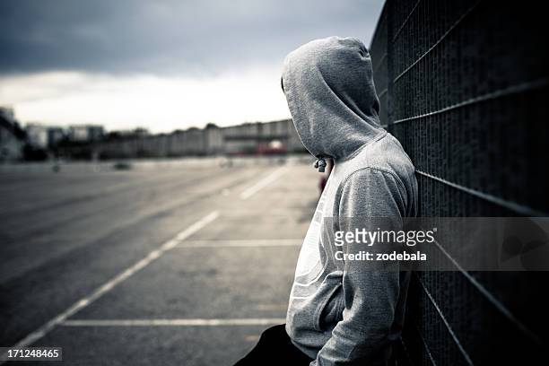 lonely man leaning on a fence - problemen stockfoto's en -beelden