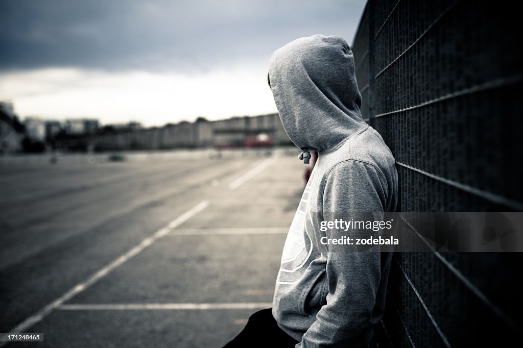 Lonely Man Leaning on a Fence