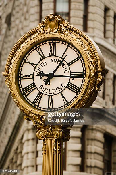 fifth avenue building clock with the flatiron in background - fifth avenue stock pictures, royalty-free photos & images