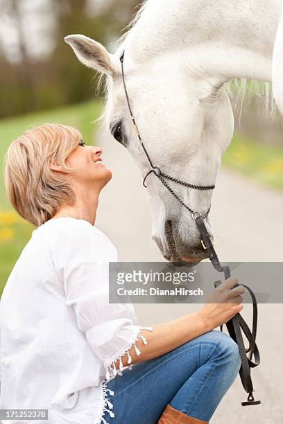友情の女性とホワイトのホース - arab horse ストックフォトと画像