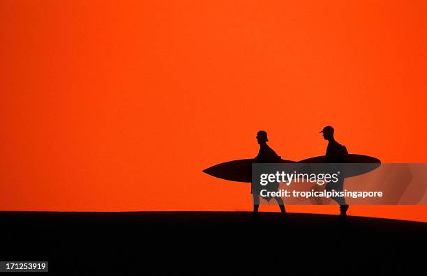 morocco, agadir, surfers walking on sand dune. - agadir stock pictures, royalty-free photos & images