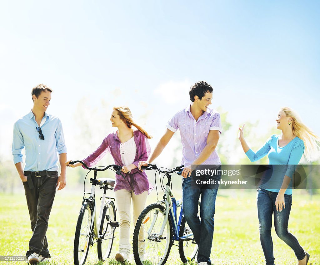 Cheerful friends with bikes in the park.