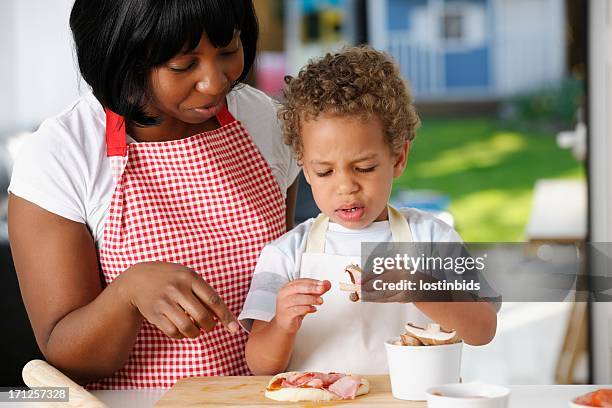 little boy olhar confundia enquanto a preparar pizza com sua mãe - lady cooking confused imagens e fotografias de stock