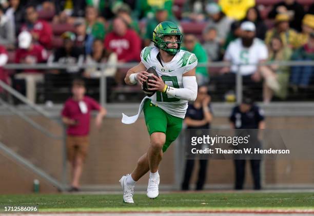 Bo Nix of the Oregon Ducks scrambling with the ball looks to pass against the Stanford Cardinal during the third quarter of an NCAA football game at...