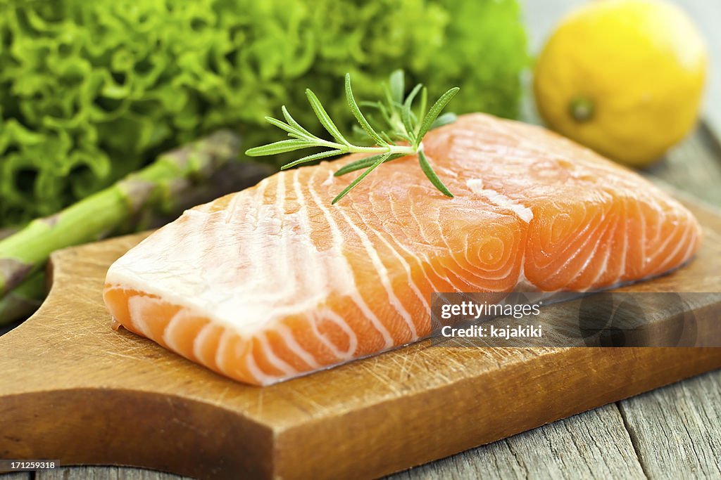 A photograph of a salmon fillet on a wooden board