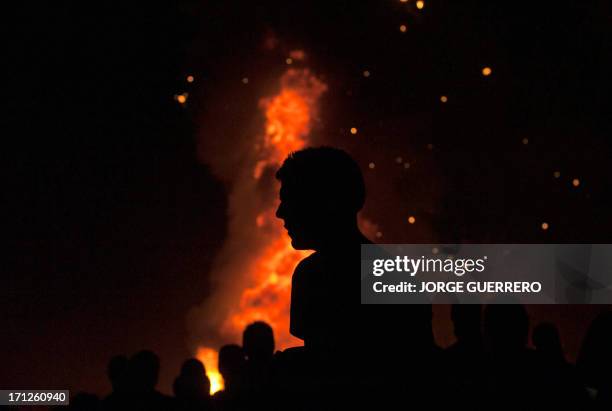 Boy walks in fron of a bonfire early on June 24 during the traditional San Juan's night in a beach of Malaga, southern Spain. Fires are lit...