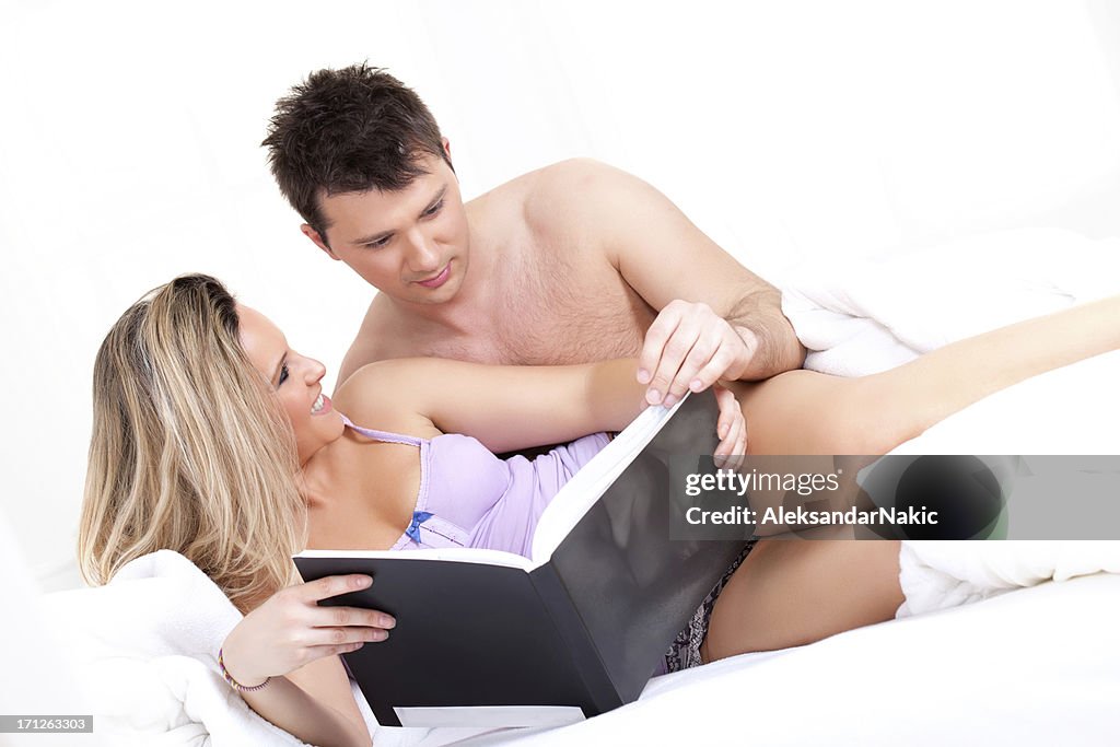 Playful couple reading a book