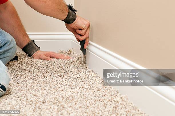 installer using carpet knife to tuck new floor - carpet stock pictures, royalty-free photos & images