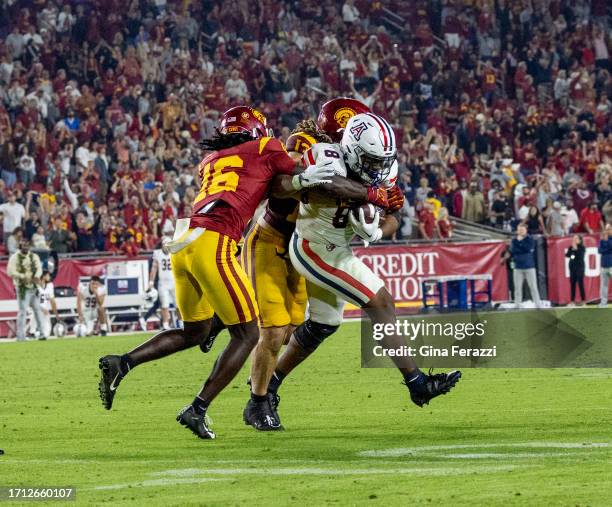 Trojans cornerback Prophet Brown and USC Trojans linebacker Mason Cobb make the final defensive stop of the game tackling Arizona Wildcats running...