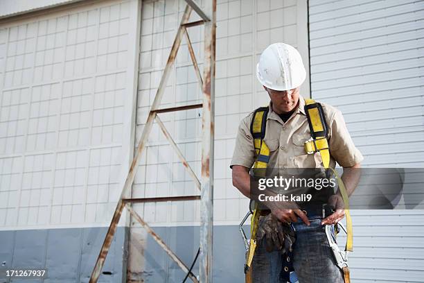 worker putting on safety harness - sele bildbanksfoton och bilder