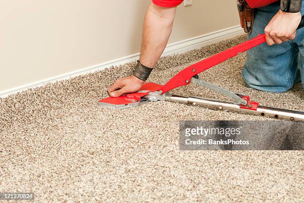 installer using carpet stretcher on new bedroom floor - tapijt stockfoto's en -beelden