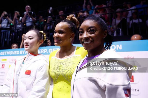 Second-placed China's Yaqin Zhou, third-placed Brasil's Rebeca Andrade and winner US' Simone Biles pose after competing in the Women's Balance Beam...