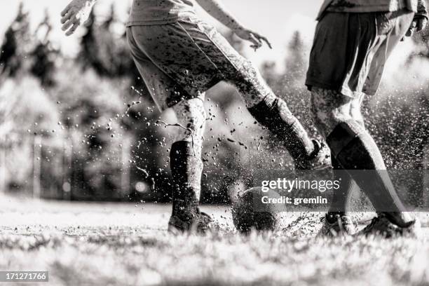zwei fußball-spieler im schlamm aktion - sepia stock-fotos und bilder