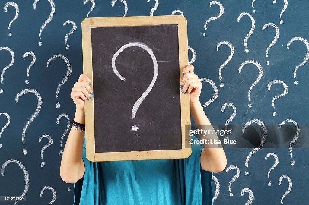 Woman holding chalkboard with question mark