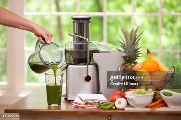 gießen ein glas frischen grünen bio-saft - saftpresse stock-fotos und bilder