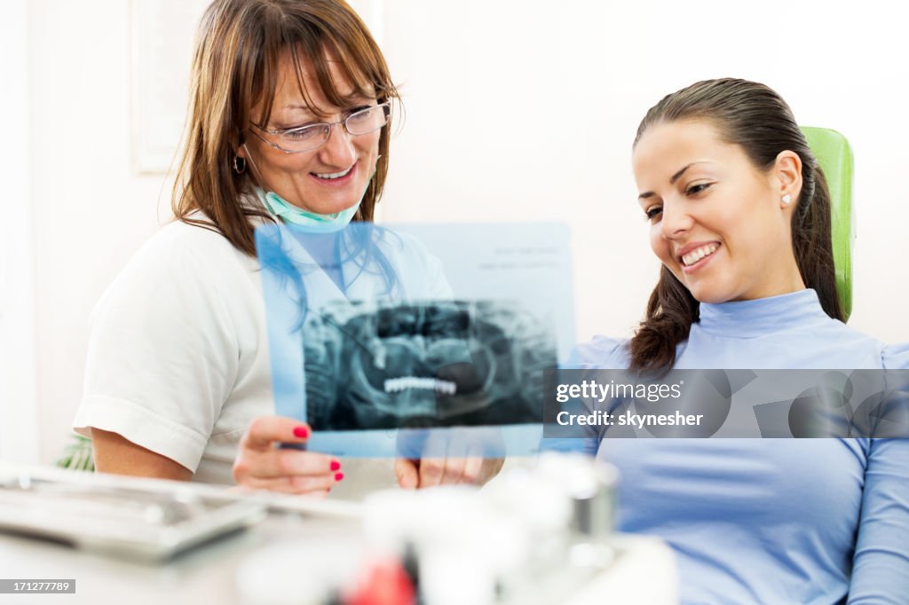 Dentist and patient looking at tooth x-ray