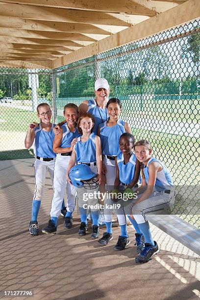 niñas softball con entrenador personal en el banquillo de campo de béisbol - sports dugout fotografías e imágenes de stock